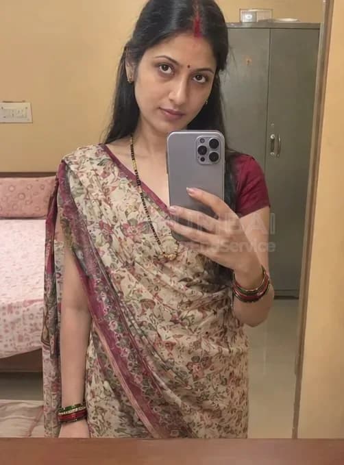 Housewife escort in a printed saree and sindoor taking a mirror selfie at home in Mumbai