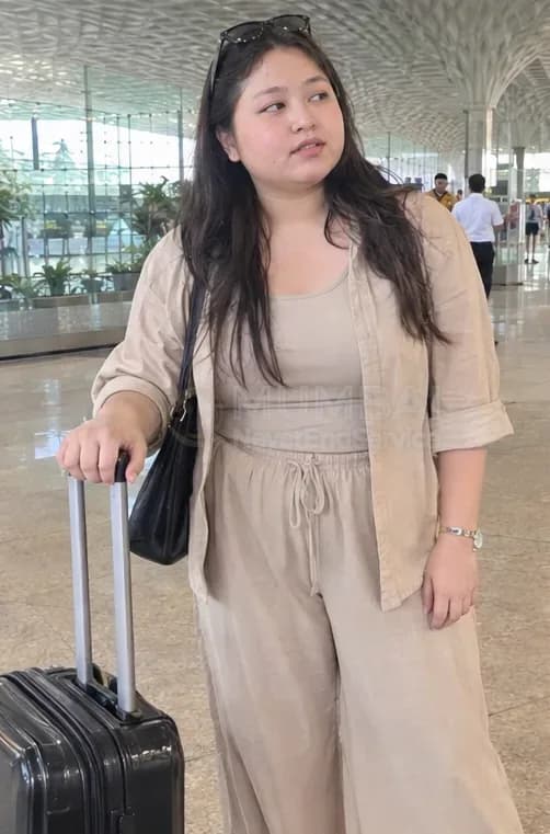 New arrival escort with a trolley bag at Mumbai airport in a beige linen outfit