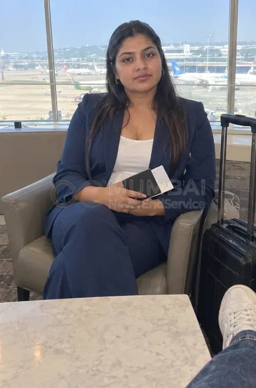 Travel companion escort in a navy suit with a boarding pass in a Mumbai airport lounge